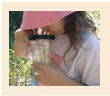 Girl looks at bugs in a glass jar