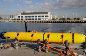 Remotely operative vehicles or ROVs, such as the one shown here, can be outfitted with 3D imaging sonar and cameras as well as chemical sensors capable of 'sniffing out' drugs or explosives on the hulls of ships.  Background: SRI St. Petersburg headquarters at Bayboro Harbor. 